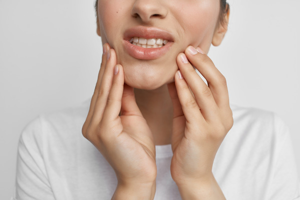 Person holding their jaw due to discomfort
